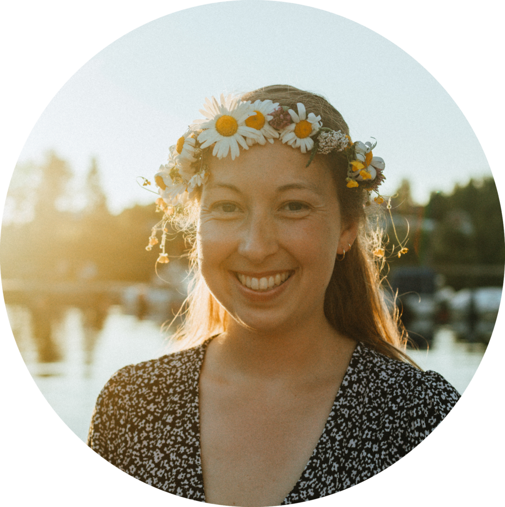Anna mit breitem Lächeln und einem Blumenkranz